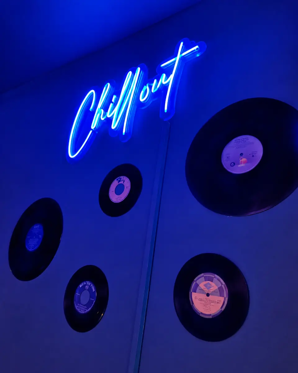 Blue Chillout neon above vinyl records on the wall