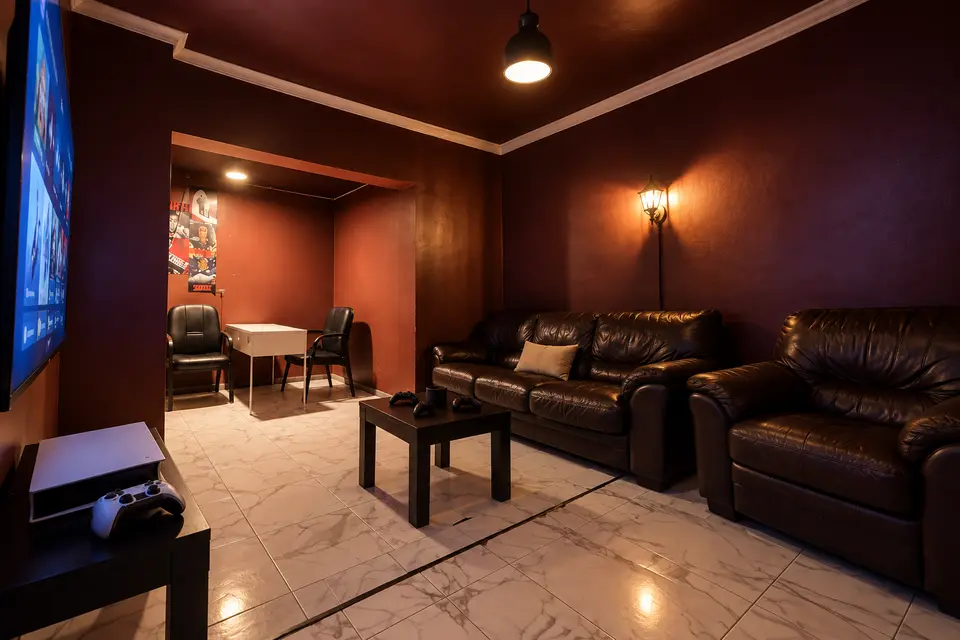 Room 04 from the TV side, leather sofas under a warm lamp